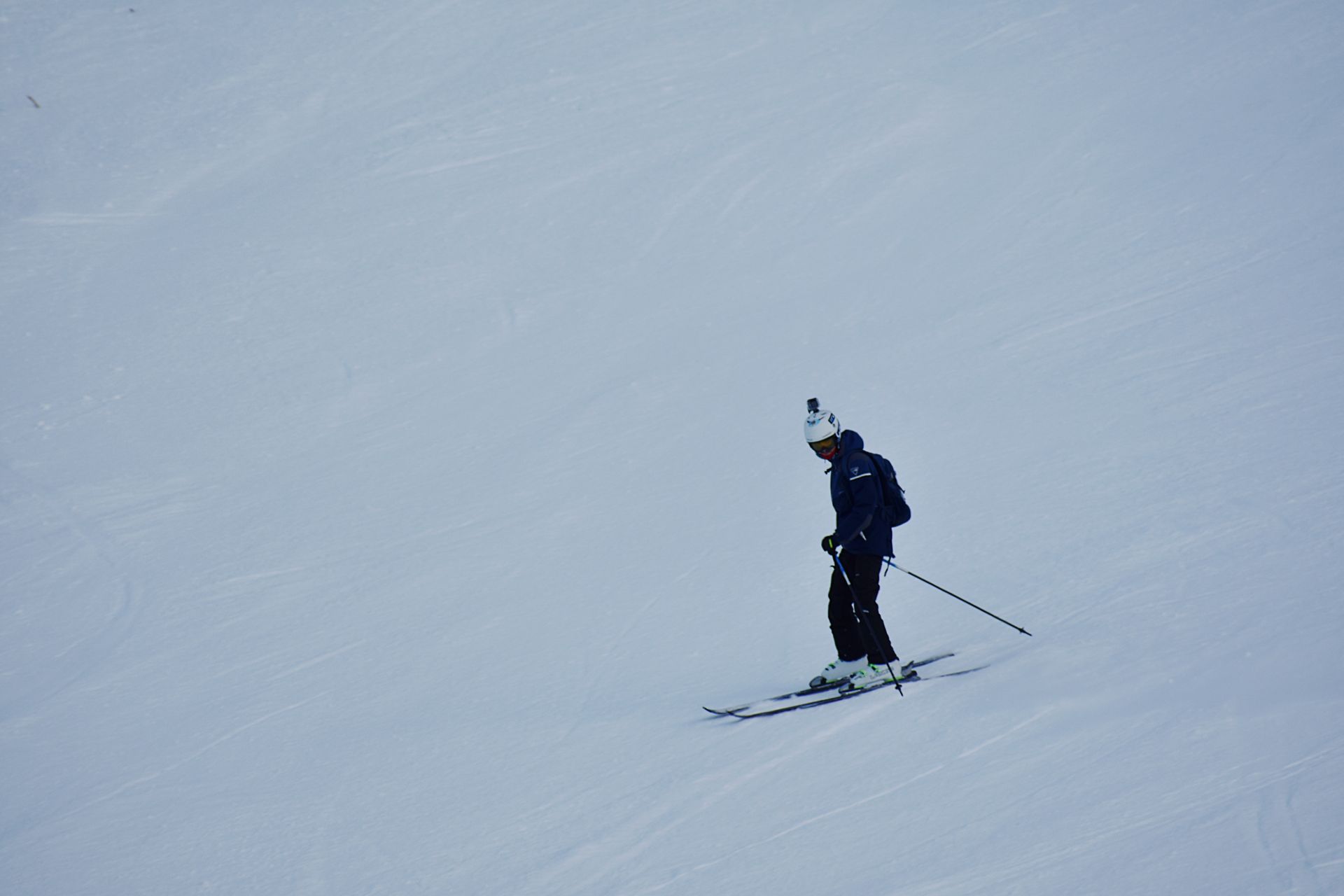 A skier navigating a snowy slope, showcasing winter sports and seasonal recreation.