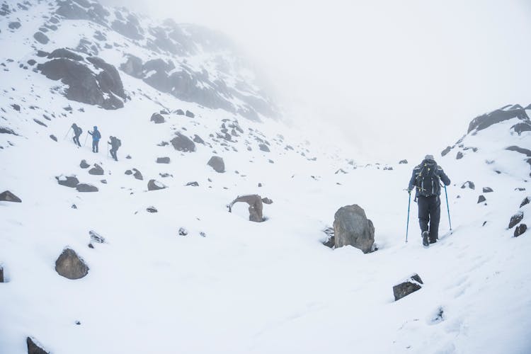 People Hiking In Mountains In Snow