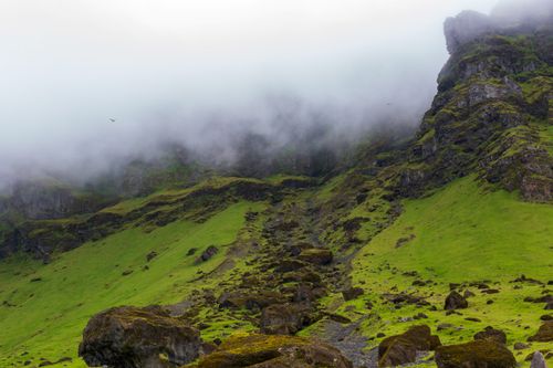 Free A stunning mist-covered mountain landscape with lush greenery and rugged rocks. Stock Photo
