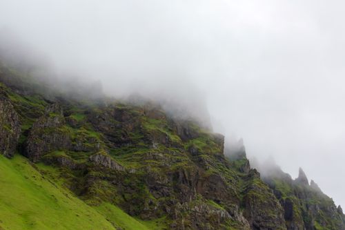Free Discover the serene beauty of a mist-covered mountain with lush greenery and rocky terrain. Stock Photo