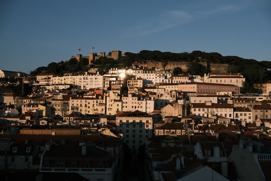 A stunning sunset view of São Jorge Castle in Lisbon, Portugal, highlighting medieval architecture.