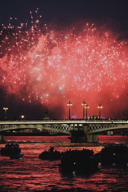 A Firework Display over a River in City 
