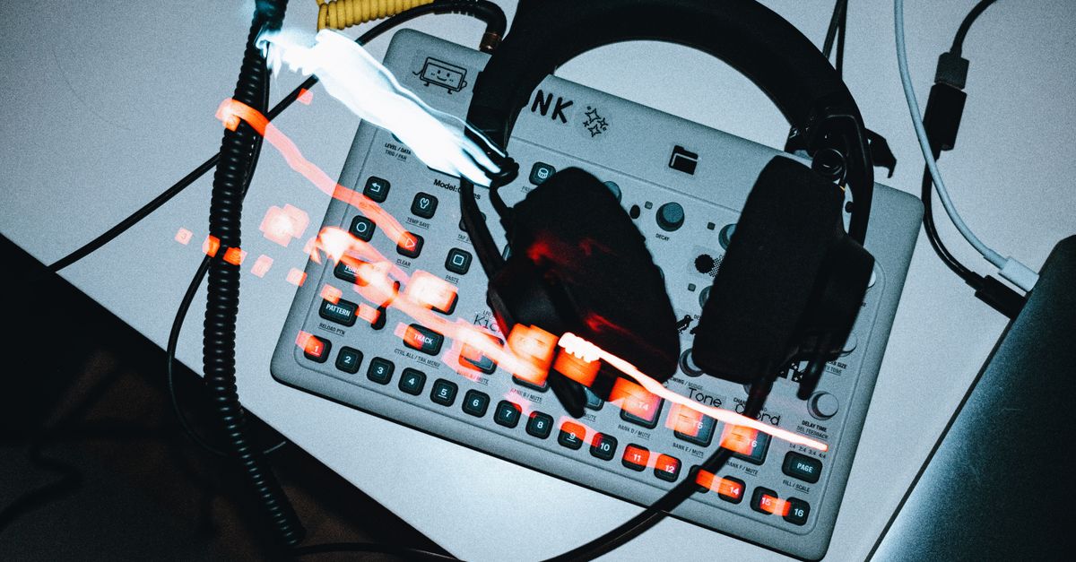 headphones resting on a music production desk with synthesizers