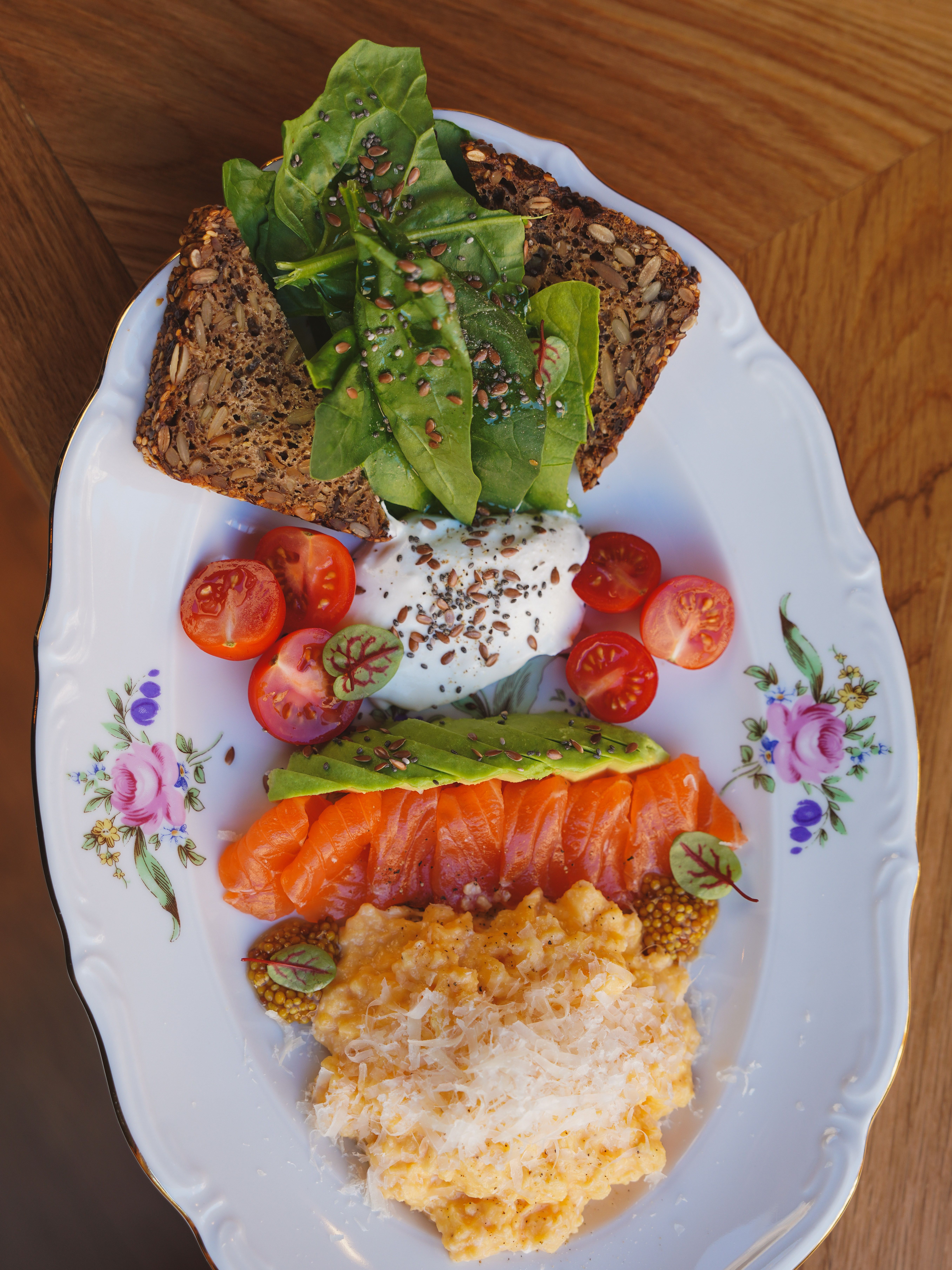 Plated healthy breakfast featuring salmon, avocado, and whole grain toast.
