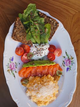 Plated healthy breakfast featuring salmon, avocado, and whole grain toast.
