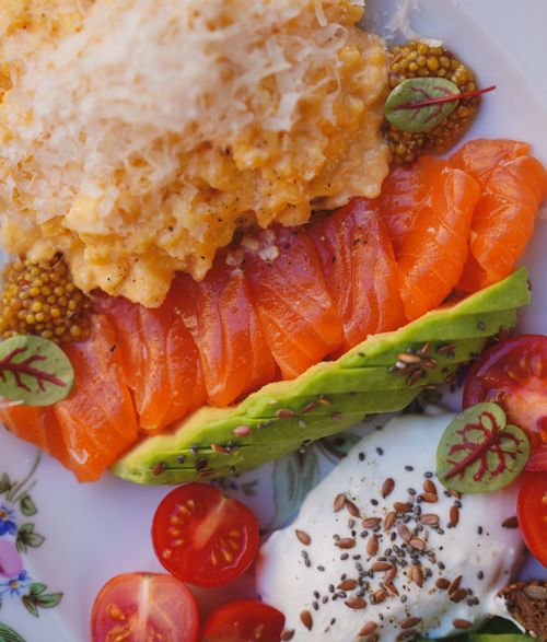 Free A vibrant breakfast plate with salmon, scrambled eggs, avocado, and cherry tomatoes. Stock Photo