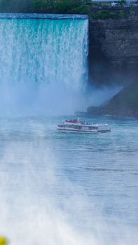 A tour boat navigates close to the stunning Niagara Falls, offering a breathtaking view.