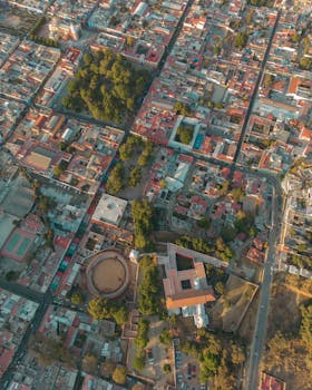 Drone view of Tlaxcala cityscape showcasing its streets, buildings, and greenery.