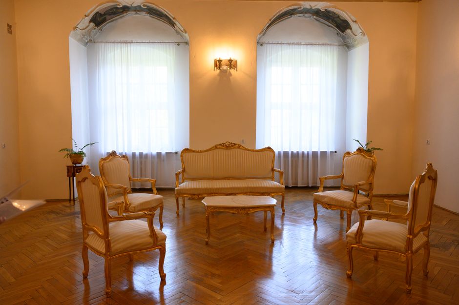 Salon w mieszkaniu z odnowionym dębowym parkietem w jodełkę, jasnymi ścianami i meblami, przykład renowacji parkietu.