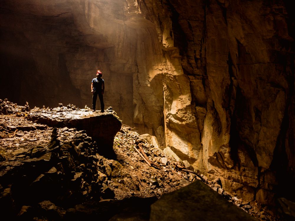 Man Standing inside a Rocky Cave · Free Stock Photo