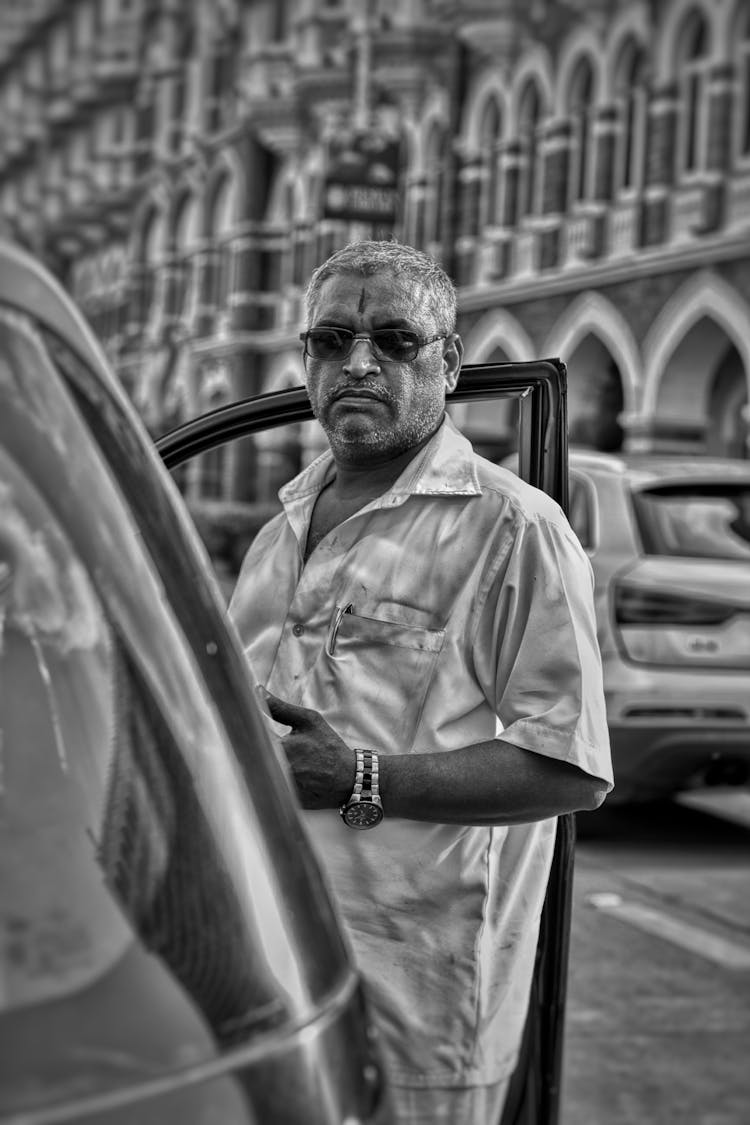 A Man Standing By A Car