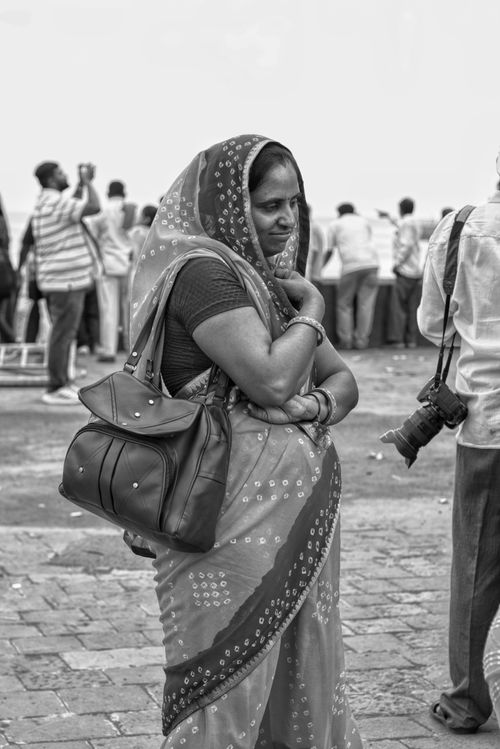 Free Indian woman in traditional attire with onlookers in the background, black and white photograph. Stock Photo