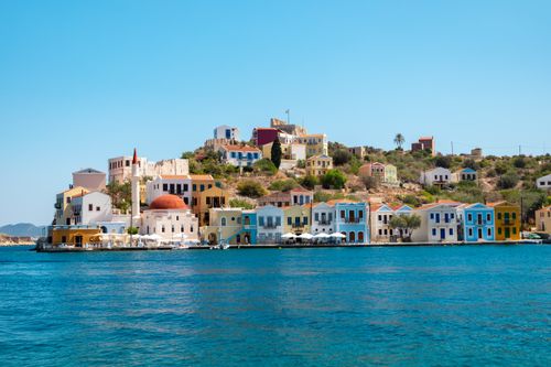 Free Vibrant waterfront buildings in Kastellorizo, Greece with blue seas and clear skies. Stock Photo