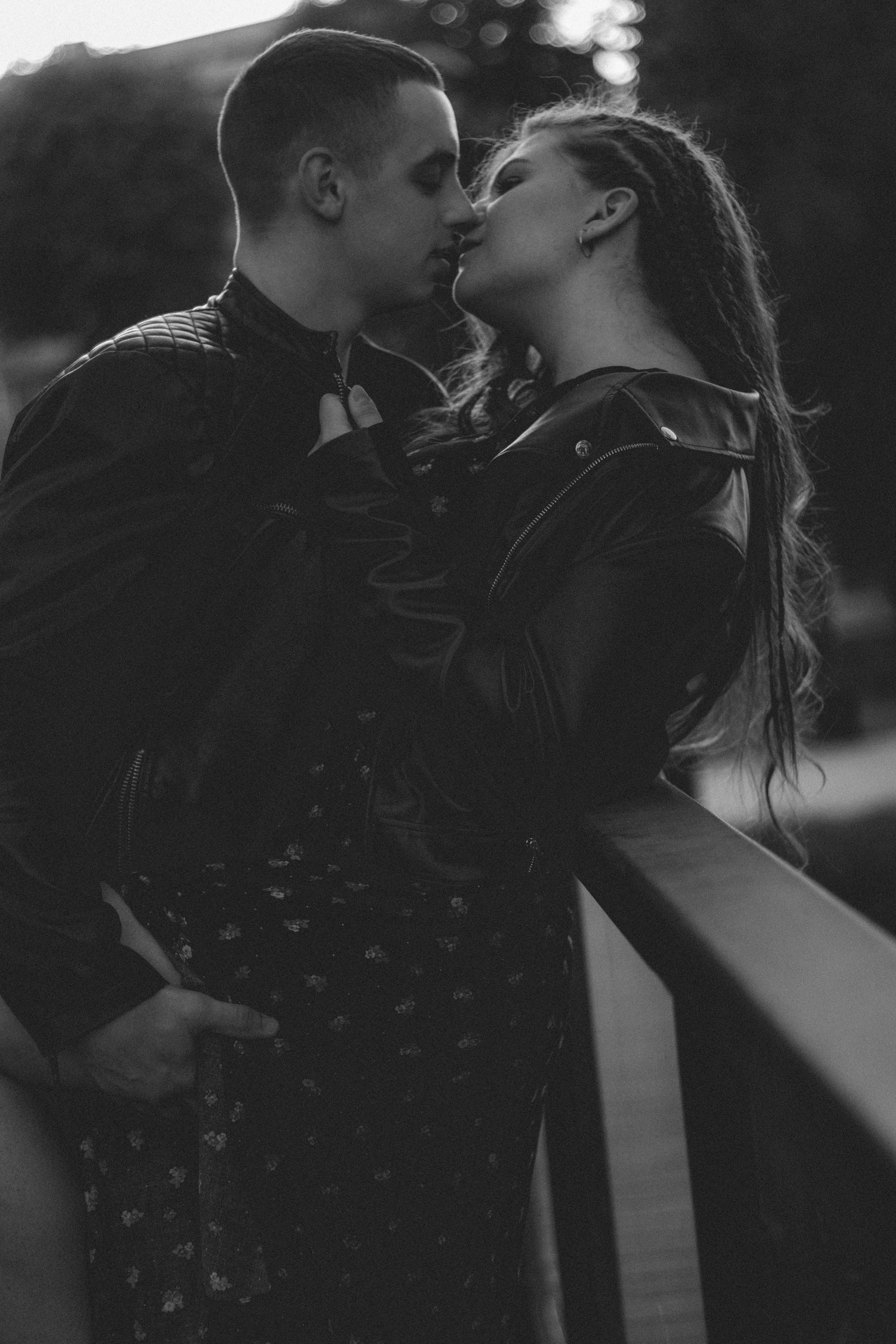 Black and White Photo of a Young Couple in Leather Jackets Kissing on a ...