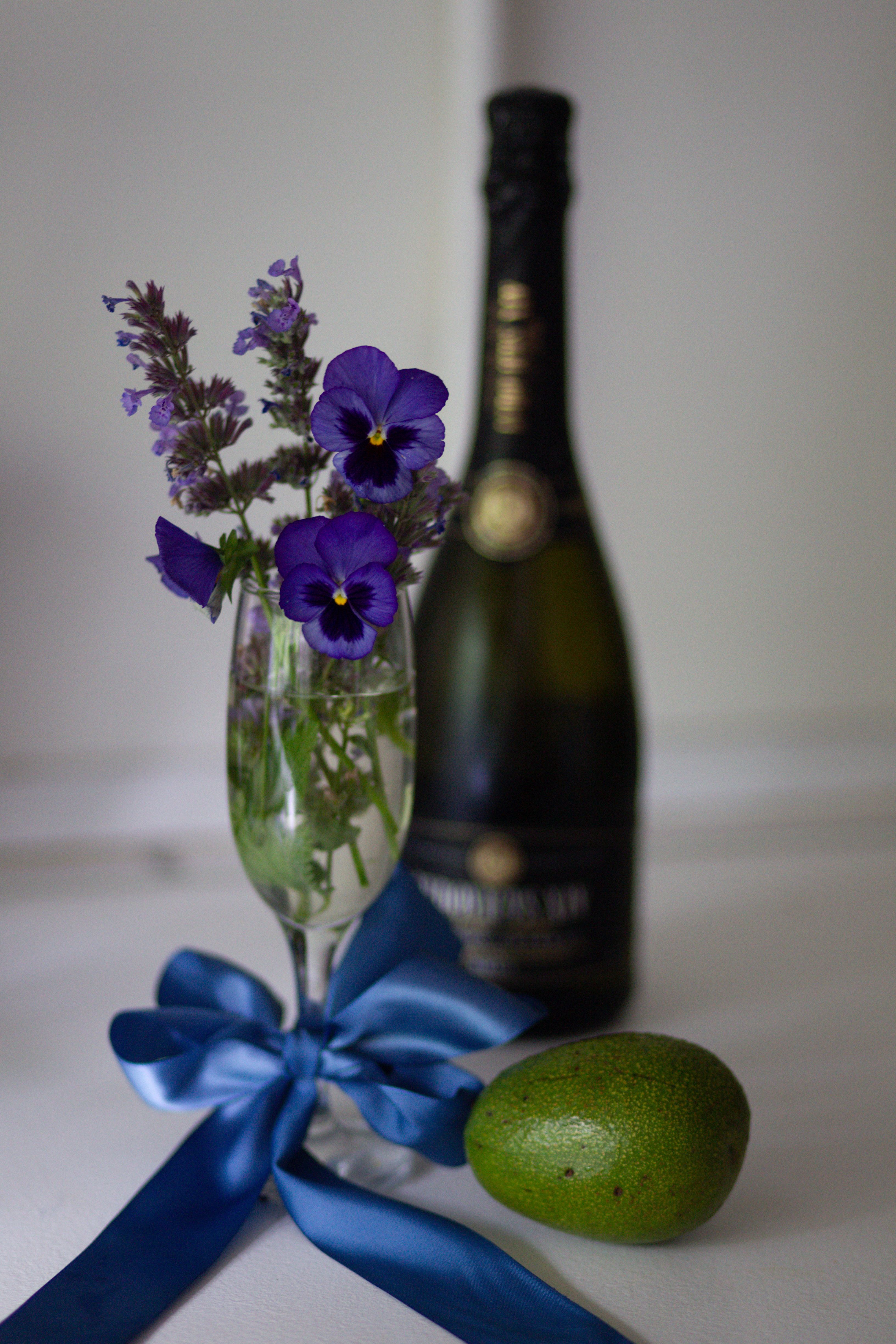 A floral arrangement with champagne and avocado, perfect for celebrations.