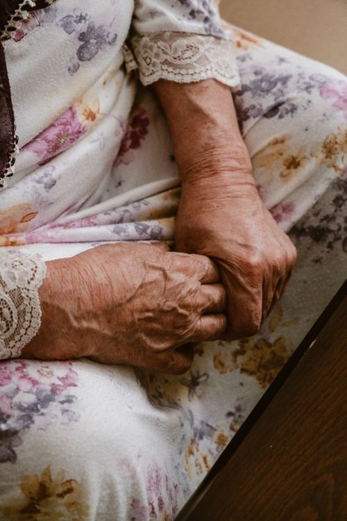 Close-up of an elderly woman's hands clasped together
