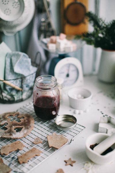 Jar of homemade berry preserve on a cooling rack with spiced biscuits, photo by Lina Kivaka on Pexels