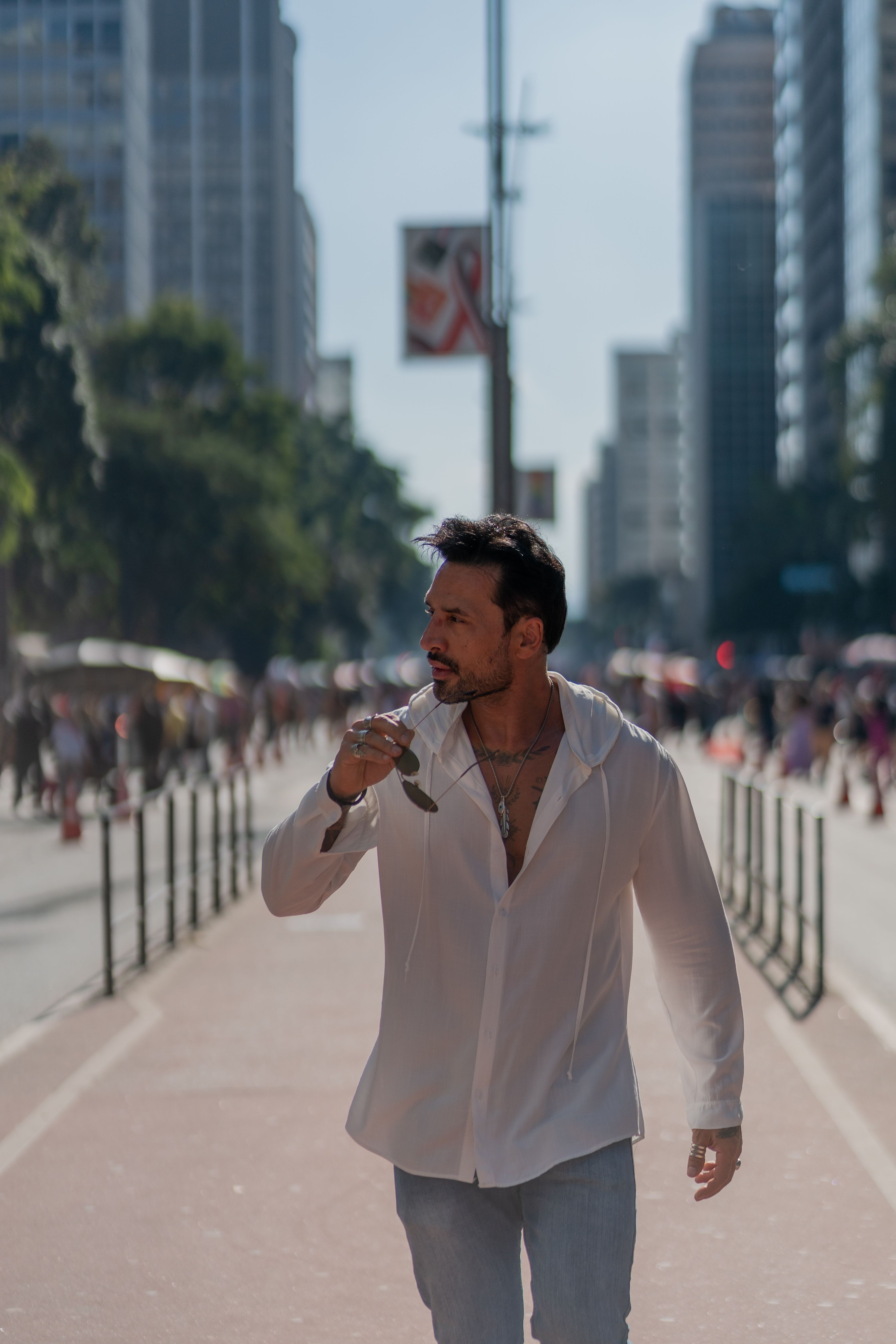 A stylish man walks down a bustling city street, exuding modern elegance.