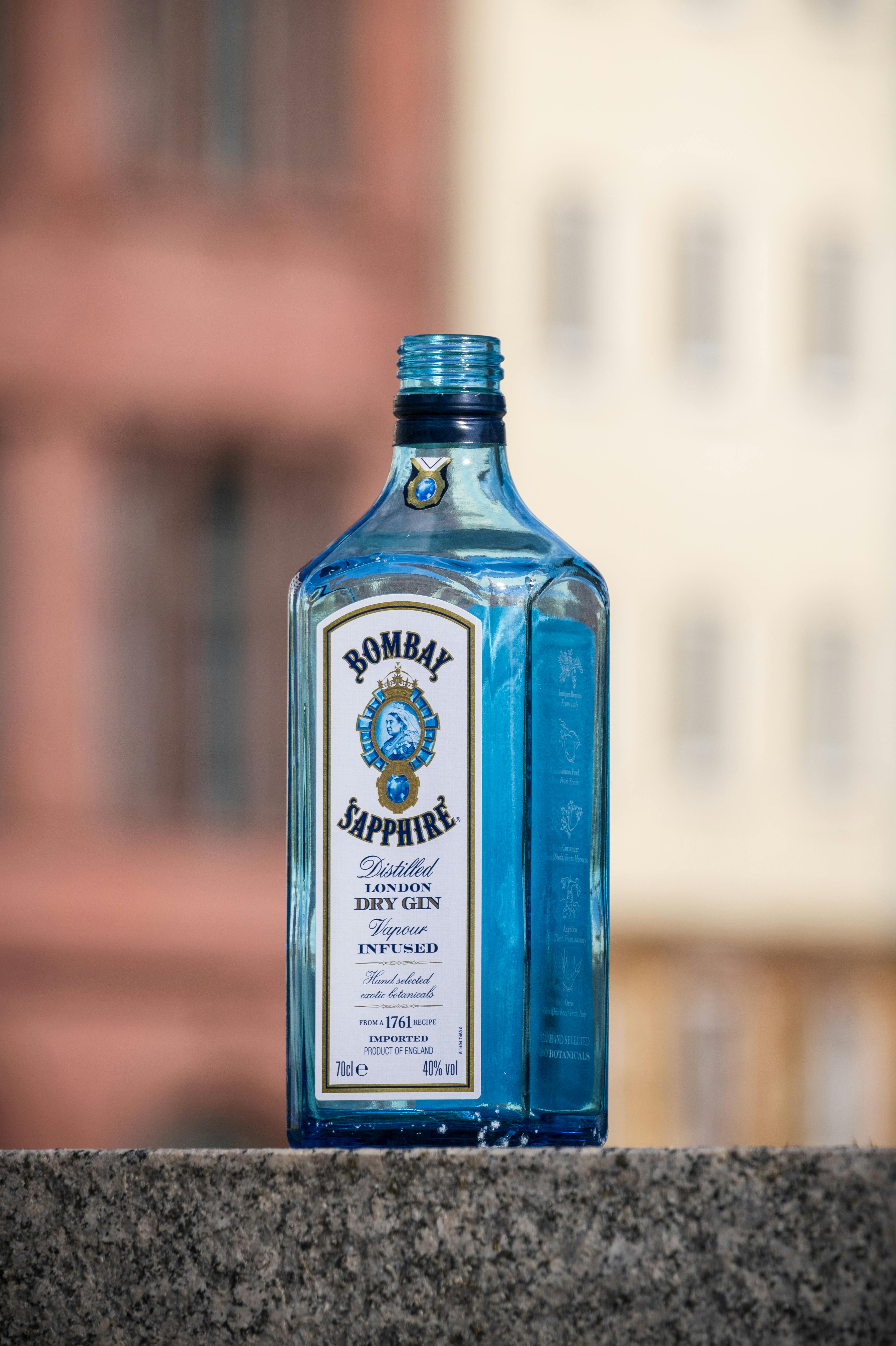 a bottle of gin on a ledge in front of a building