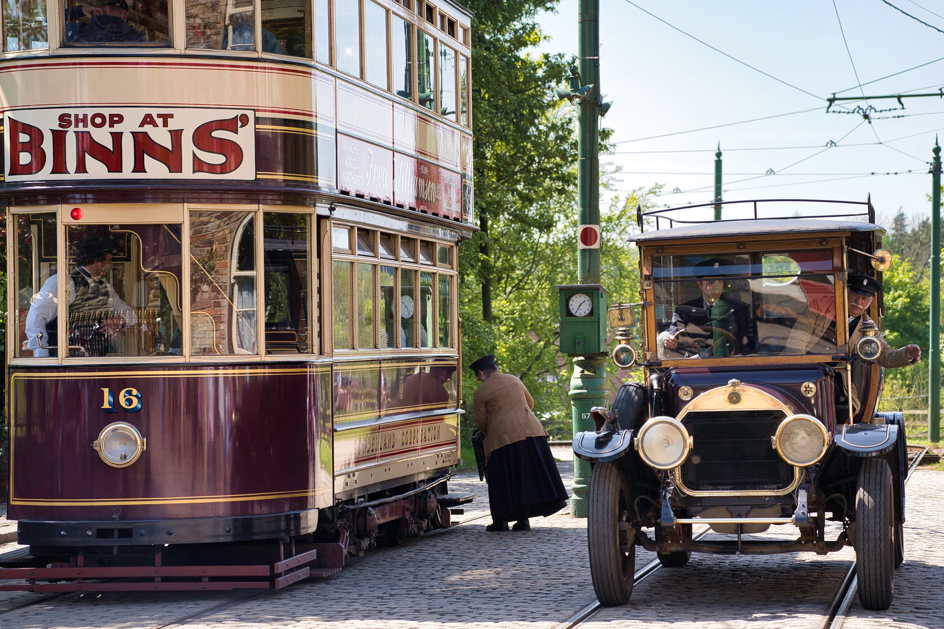 Historic tram and vintage car showcasing early 20th-century public transport.