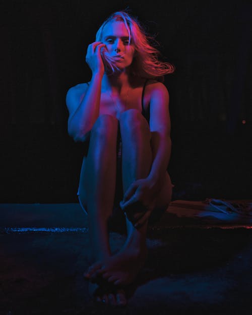 Woman Sitting in a Dark Room