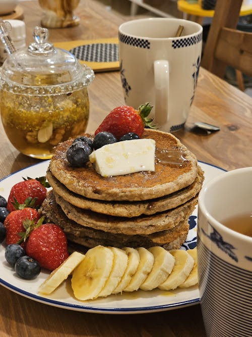 Free Pancakes with Fruits and Tea on a Table  Stock Photo