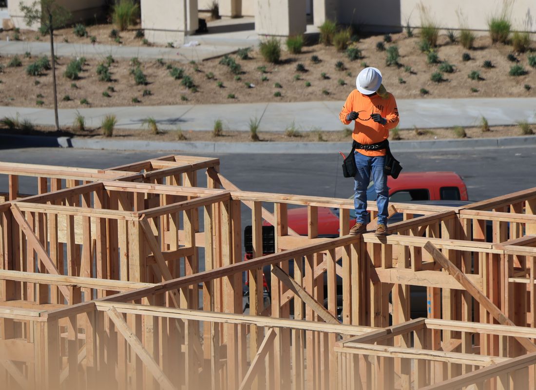 A contractor on a job site checking his phone between tasks