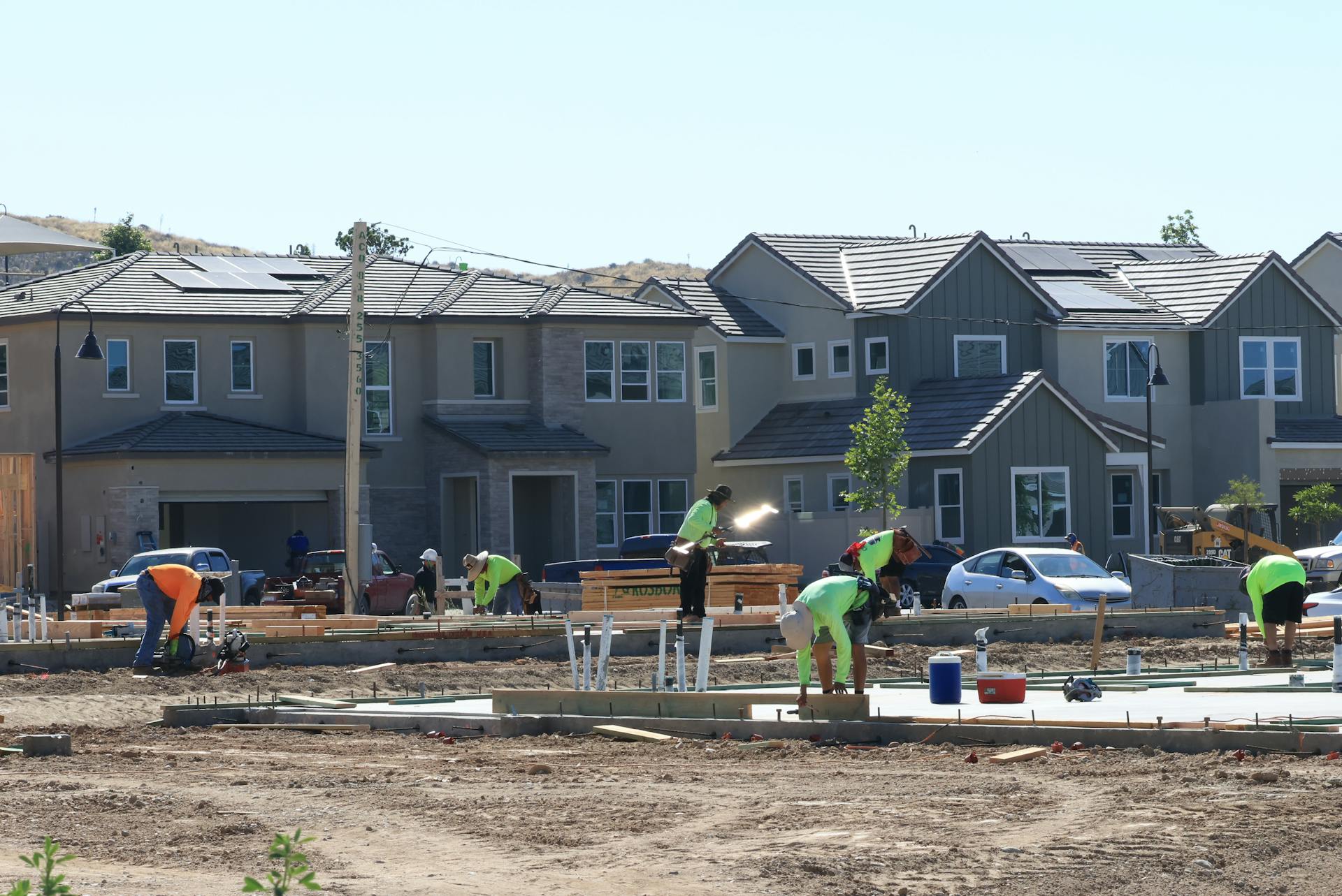 Construction workers laying foundations in a modern housing development.