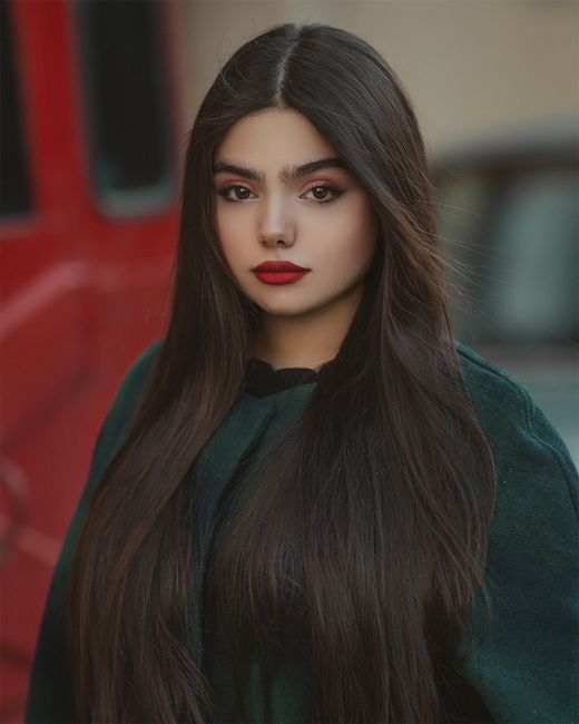 Stylish portrait of a woman with long brown hair and red lipstick captured in an urban setting. - Common Mistakes in Selecting Handbags, Like Prioritizing Brand Over Functionality