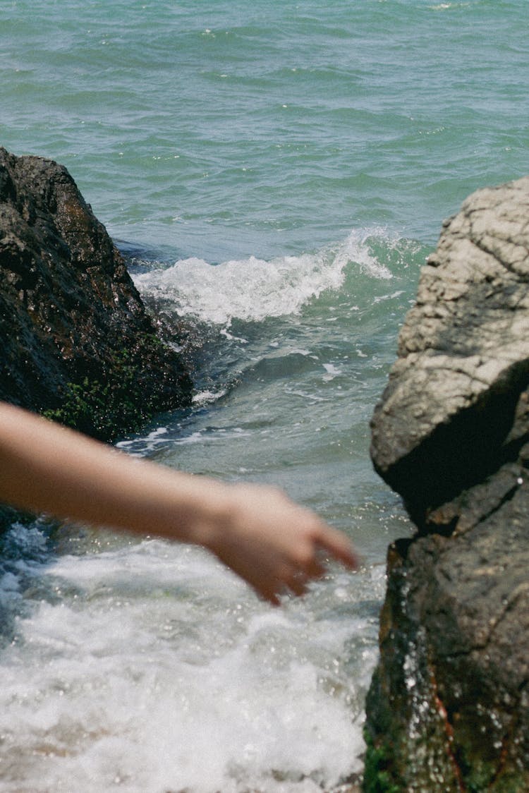 An Arm On The Background Of Rocks And The Seashore 