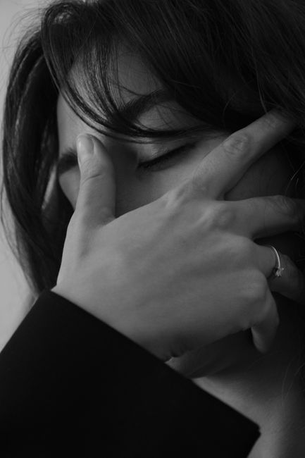 Black and white portrait of a woman with eyes closed, captured in an artistic pose.