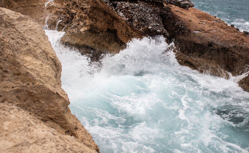 Free Powerful ocean waves crash against rugged rocks, showcasing the beauty of nature's force. Stock Photo