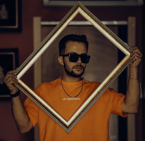 Man in Sunglasses Holding Frame