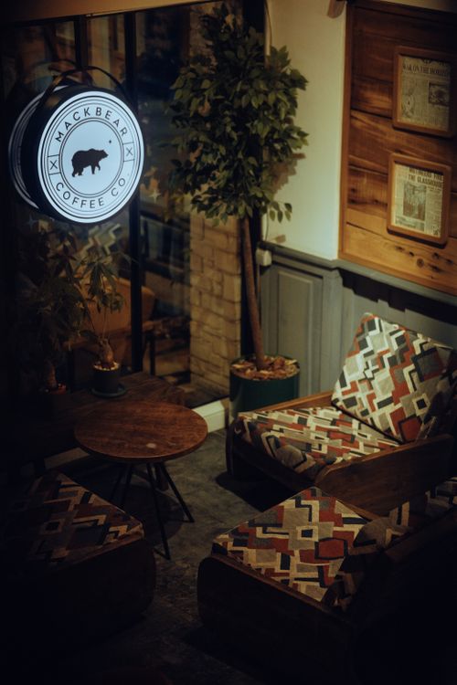 Free Warm and inviting coffee shop interior with patterned armchairs and wooden decor. Stock Photo