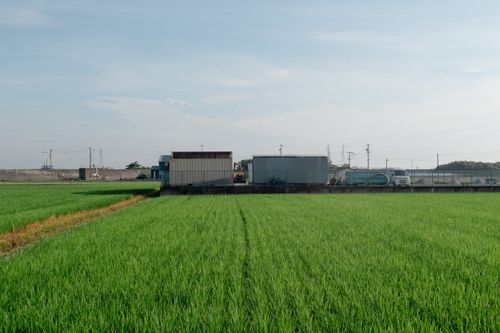 Free Expansive green field with industrial backdrop in Toyohashi, Aichi, Japan on a sunny day. Stock Photo