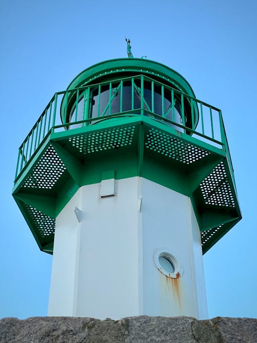 Low Angle Shot of a Lighthouse with a Green Top 