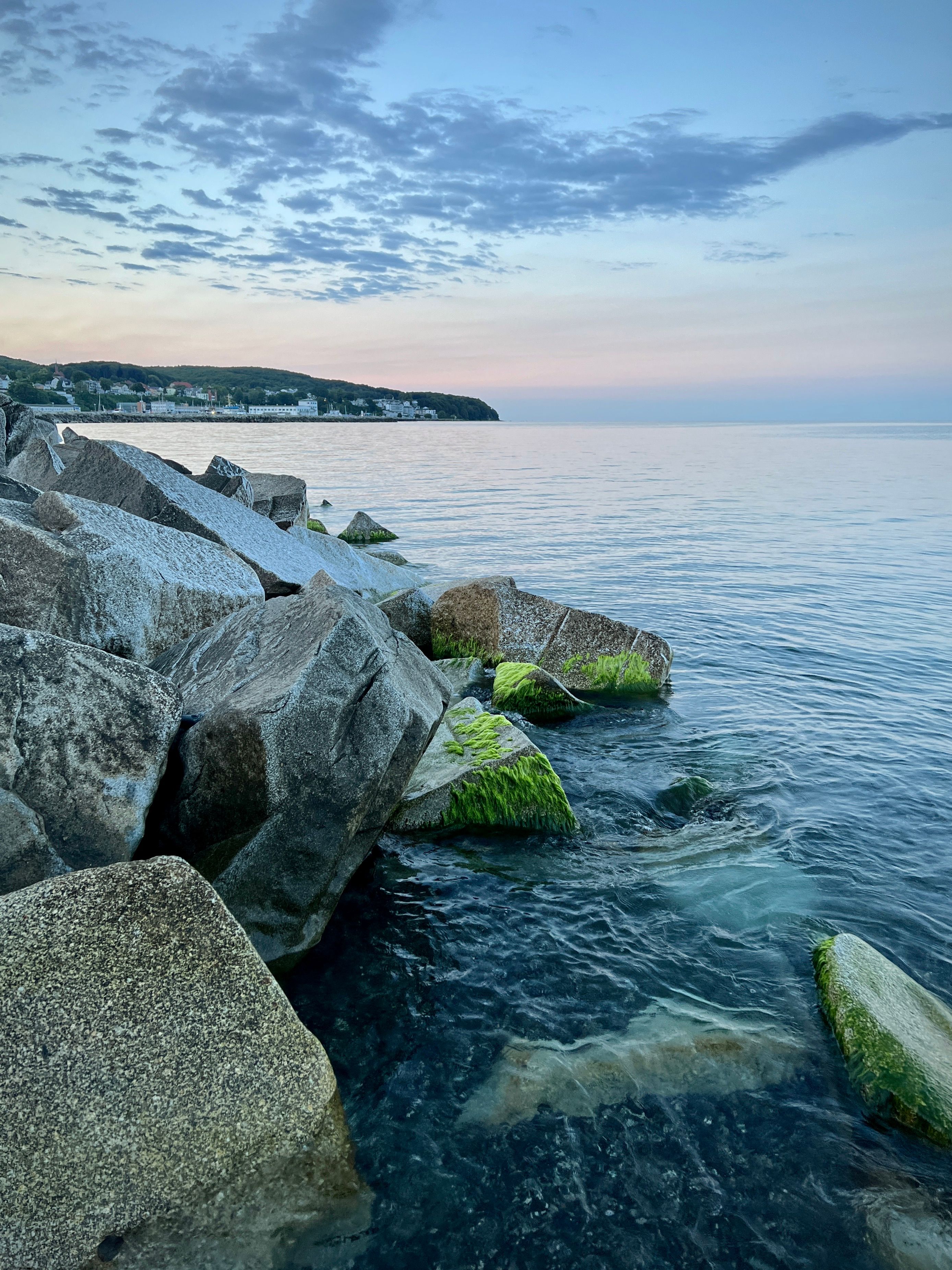 A Rocky Shore and View of a Coastal Town in Distance · Free Stock Photo