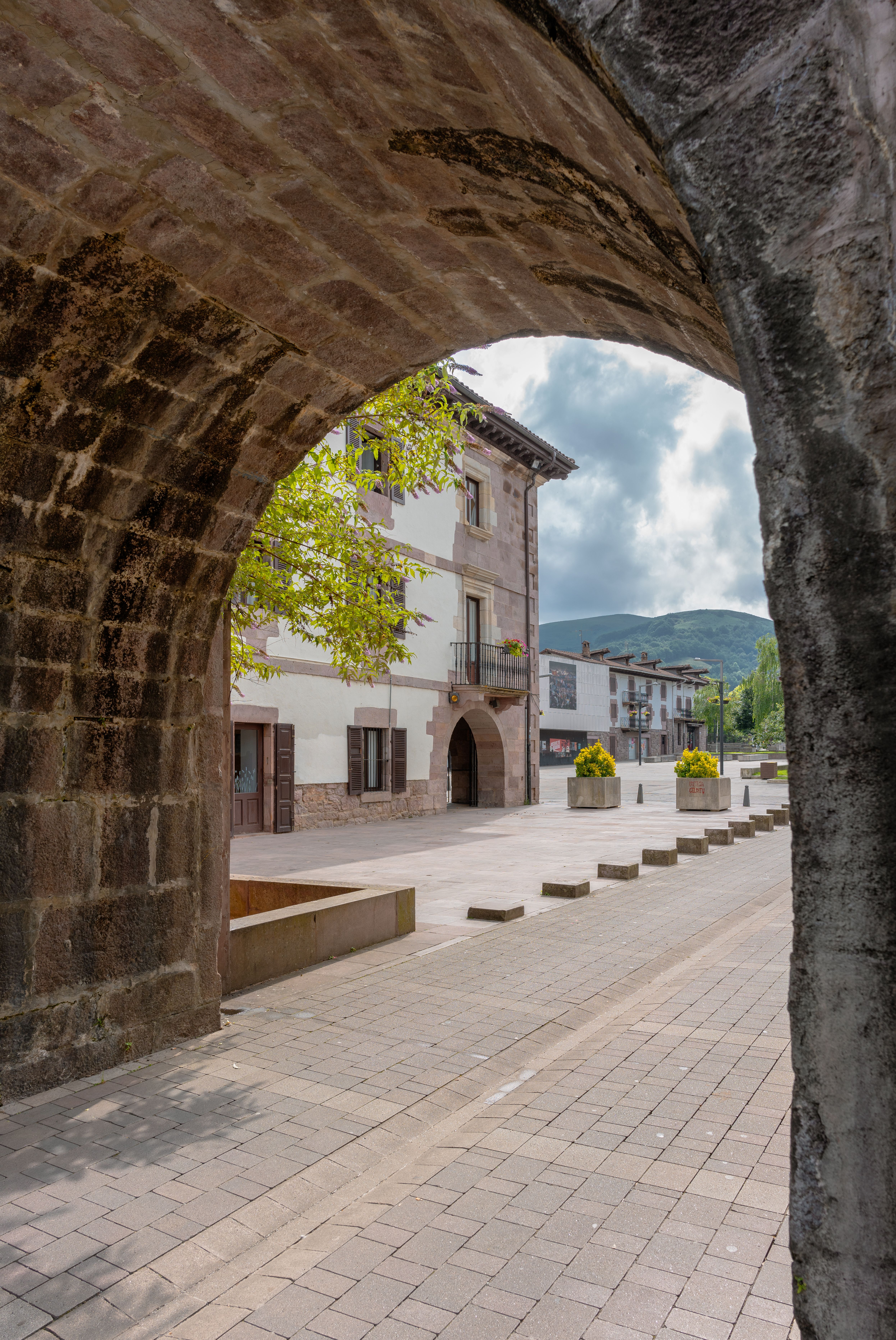 Scenic view of a historic street through an old archway in Elizondo, Spain.