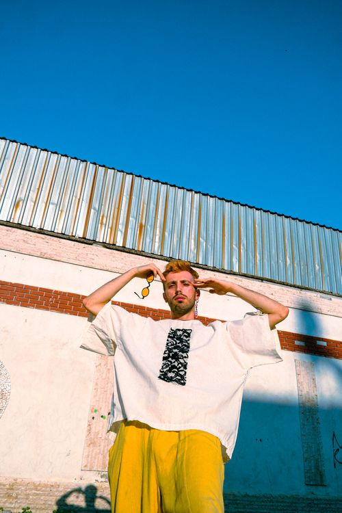 Free Stylish adult man posing outdoors against a wall, under a clear blue sky. Stock Photo