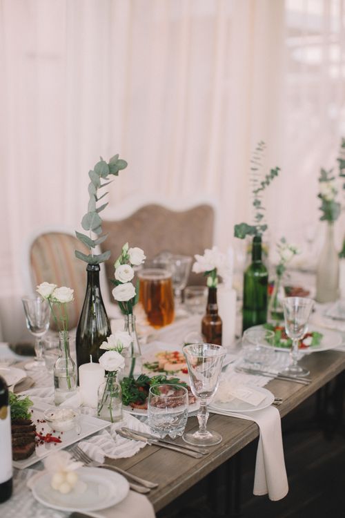 Free Charming table setup with white flowers, glassware, and wine bottles, perfect for events. Stock Photo