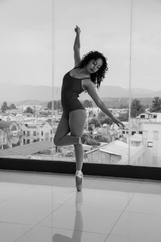 Ballet dancer gracefully posing in an airy urban studio, expressing poise and elegance.