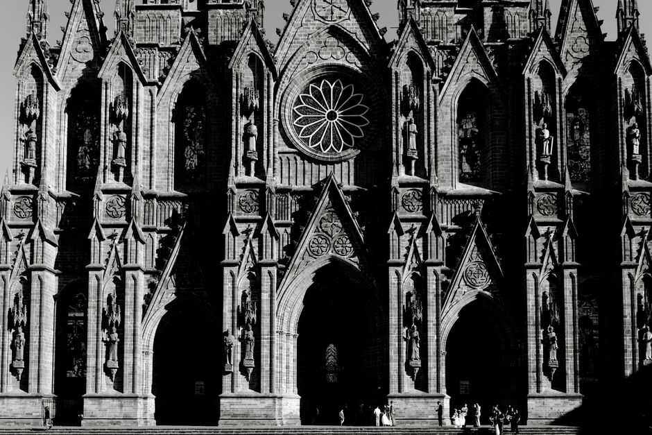 Dramatic Gothic cathedral facade captured in black and white with intricate architectural details.