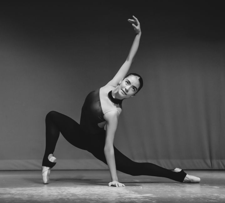 A graceful ballet dancer performing a dramatic pose in black and white.