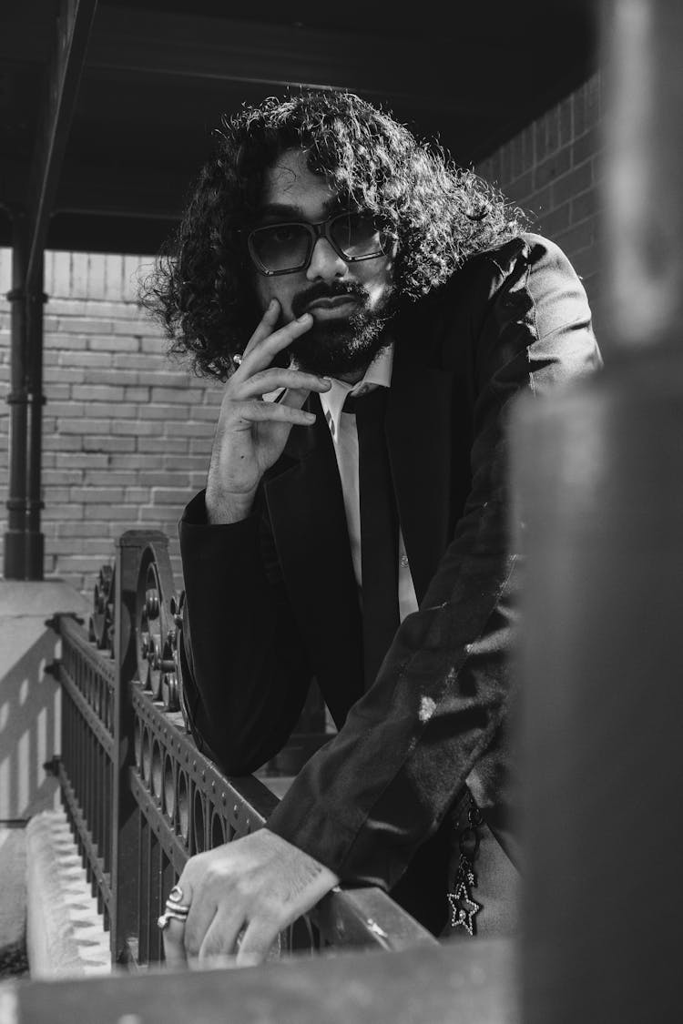 Young Bearded Man Posing In Black Blazer And Tie