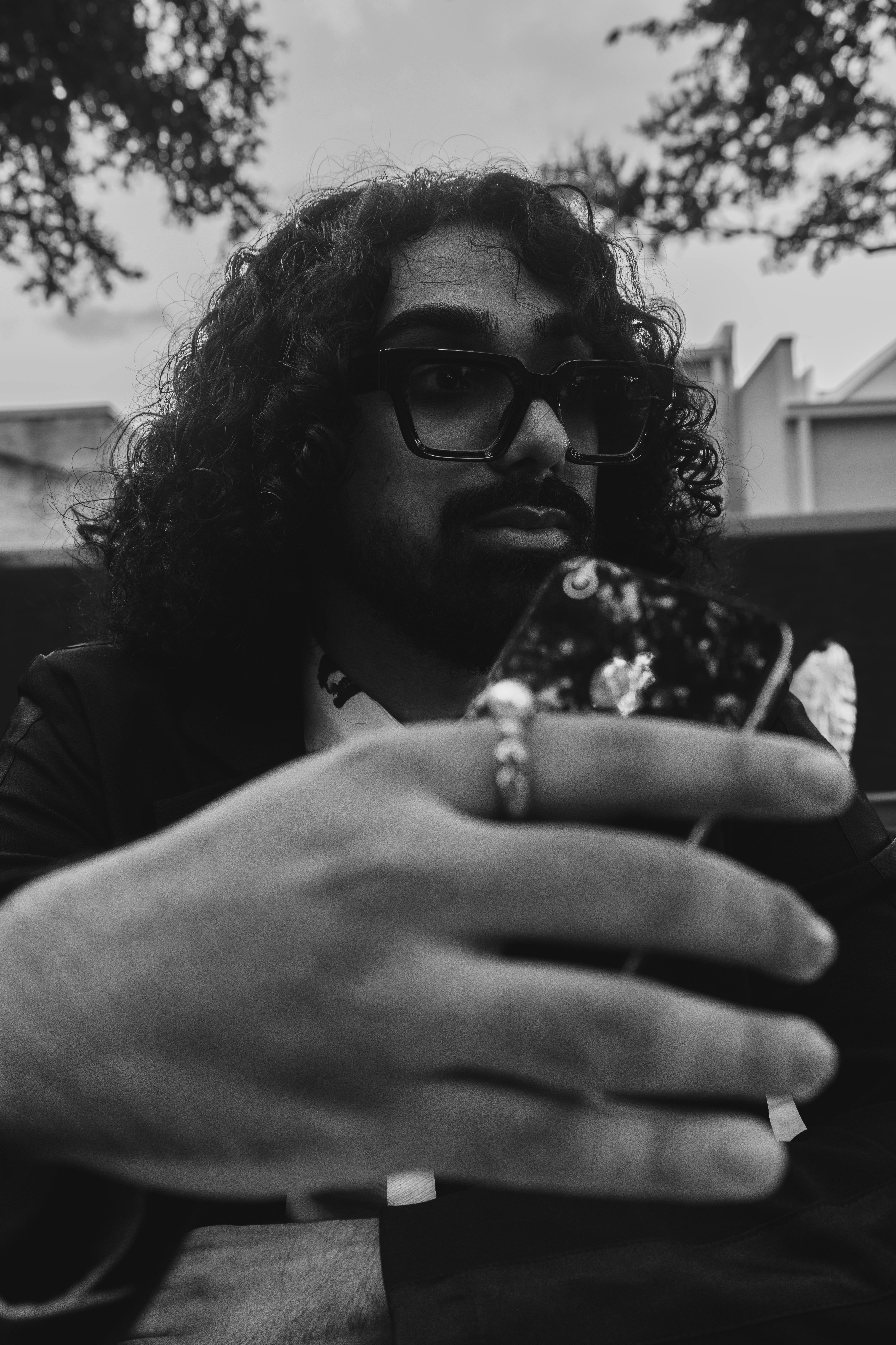 Free Black and white photo of a stylish man with curly hair taking a selfie with eyeglasses on. Stock Photo