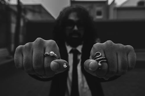 Bearded Man Showing Fists with Rings on Fingers