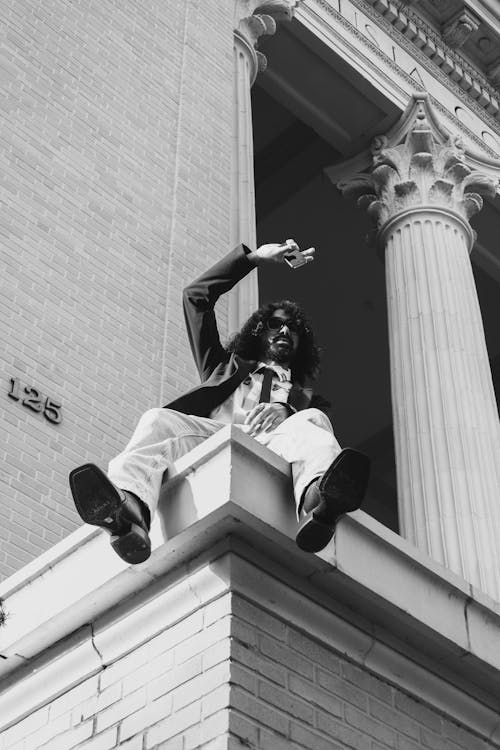 Man Posing on Building Wall with Column near