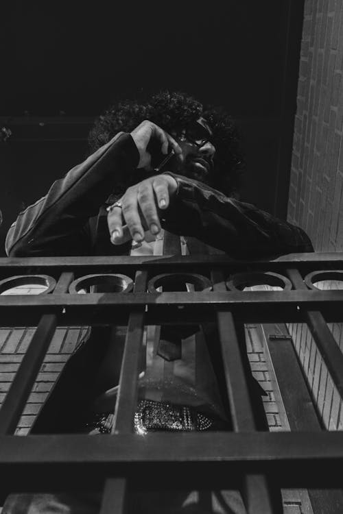 Man Leaning on Railing in Black and White