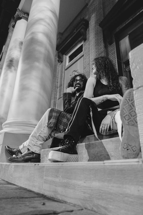 Man and Woman Sitting on the Steps of a Building 
