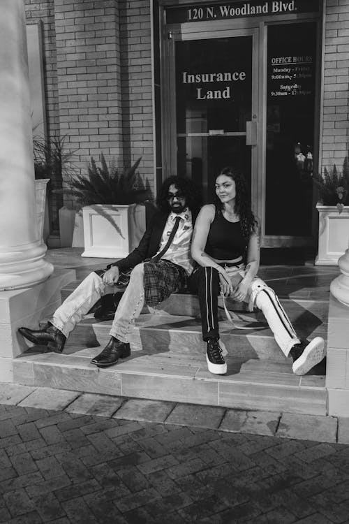 Black and White Photo of a Stylish Young Couple Sitting on Steps